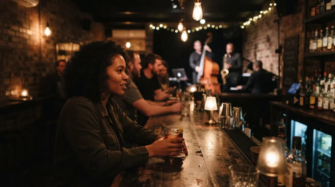 Bar Sin+Tax de noche, interior con poca luz, un cóctel en la barra y ambiente íntimo de jazz