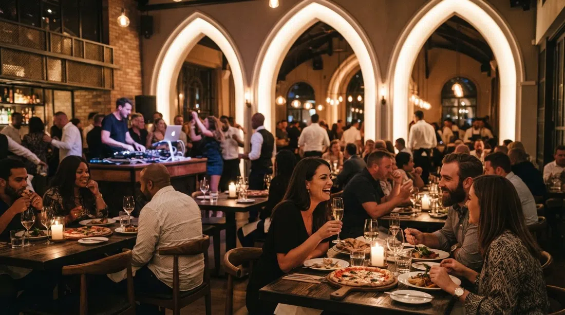Saint en The Marc con arcos de catedral, cabina de DJ y un animado comedor de pizza y champán brillando por la noche